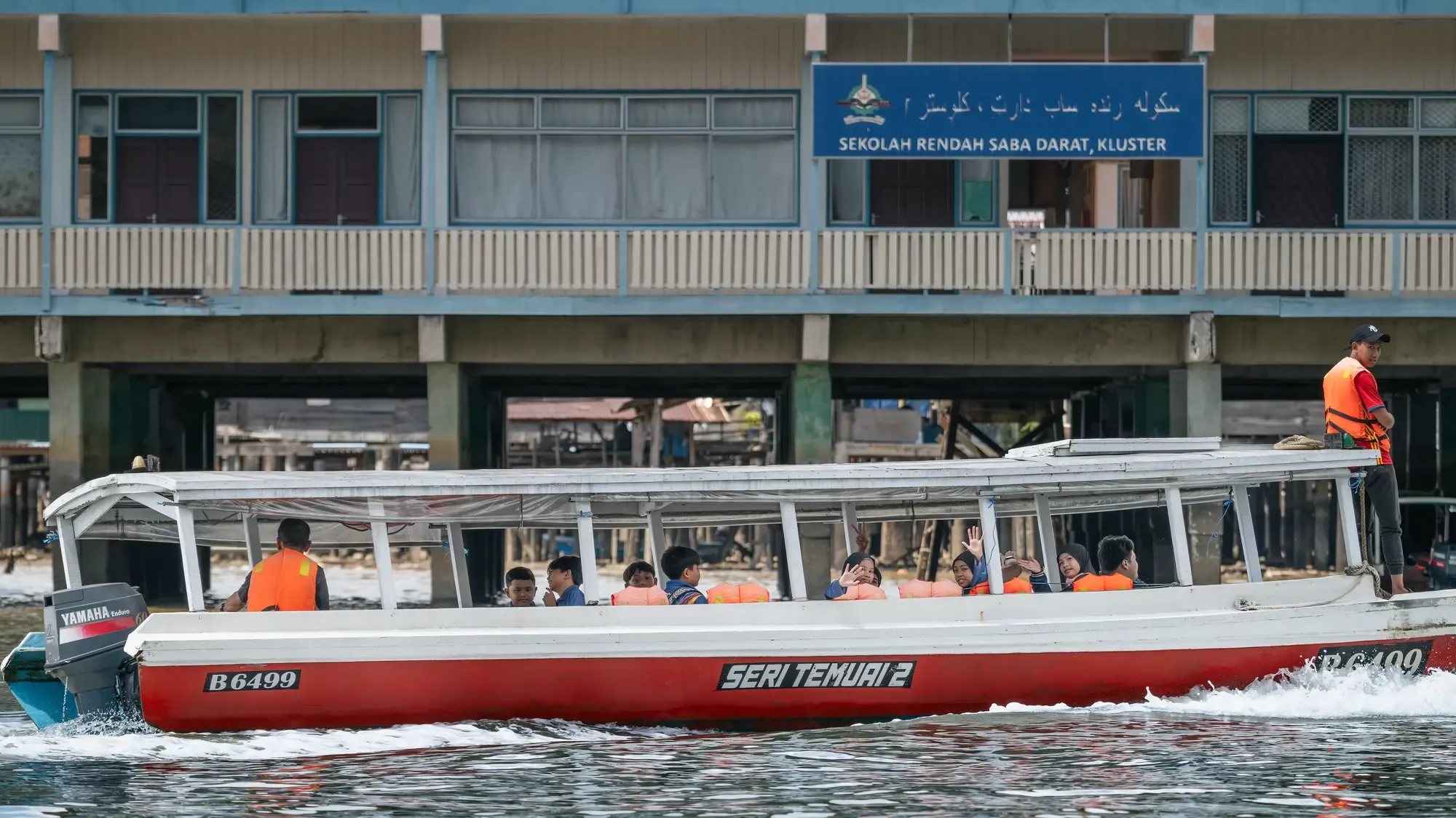 Školní loď plující po řece v Kampong Ayer